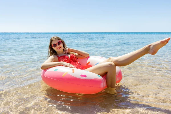 여자 여름 화창한 날에는 해변에서 풍선 도넛과 수영 — 스톡 사진