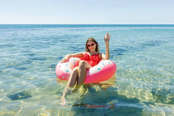 Happy brunetka žena v růžové nafukovací prstenec v létě slunečný den — Stock fotografie