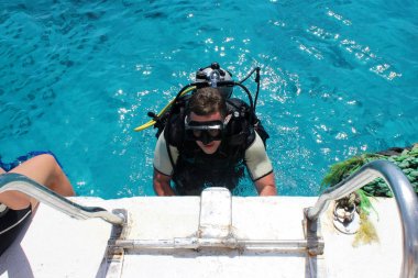 ıslak elbiseli, bir aqualung, maske ve bir balon ile bir adam. Bir dalgıç dalış viteste dalmaya hazırlanıyor.
