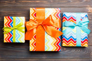 Koyu ahşap kaplamalı renkli kurdeleli kağıt hediye kutusu. Fotokopi alanı noel konseptiyle en üstteki görünüm