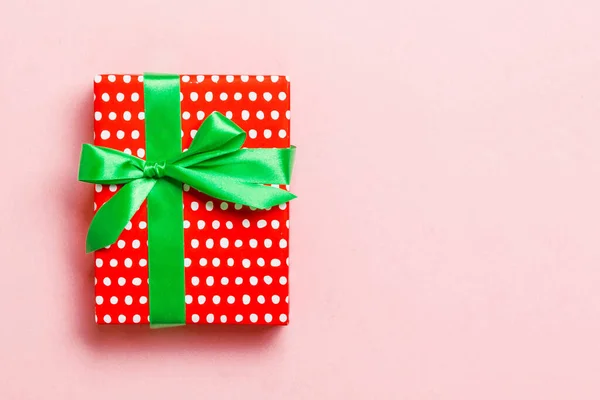 Κουτί δώρου με πράσινο φιόγκο για την ημέρα των Χριστουγέννων ή της Πρωτοχρονιάς σε ροζ φόντο, πάνω άποψη με αντίγραφο χώρου — Φωτογραφία Αρχείου