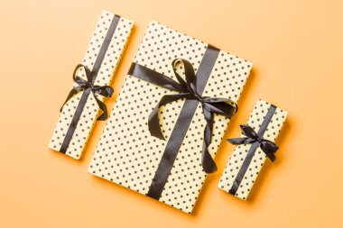 En üstteki Noel hediyesi kutusunda turuncu arka planda siyah fiyonk