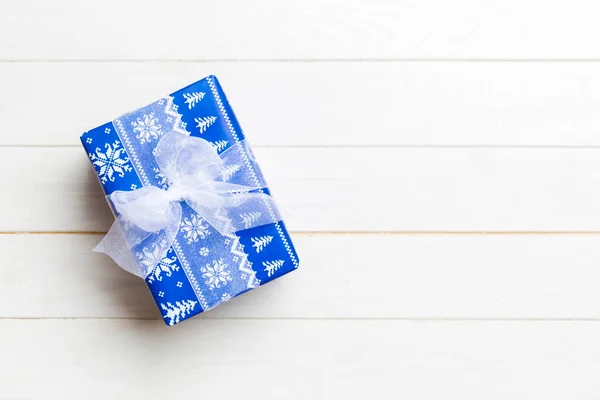 Hermosa caja de regalo con un lazo de color en la mesa de madera blanca. Vista superior con espacio de copia para su diseño. Concepto de Navidad — Foto de Stock