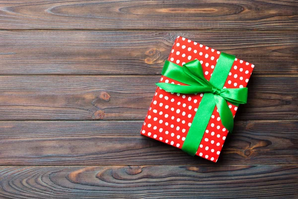 Κάτοψη του χριστουγεννιάτικου ή άλλου χειροποίητου πακέτου δώρου διακοπών, επίπεδο lay σκούρο ξύλινο υπόβαθρο με αντιγραφικό χώρο. νέο έτος κουτί δώρου — Φωτογραφία Αρχείου