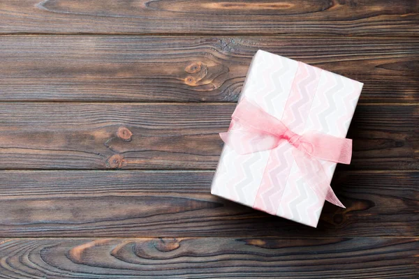 Schöne Geschenkschachtel mit einer farbigen Schleife auf dem dunklen Holztisch. Draufsicht mit Kopierraum für Ihr Design. Weihnachtskonzept — Stockfoto