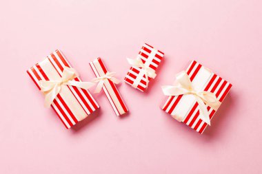 Pembe arka planda sarı fiyonklu Noel hediyesi kutusu