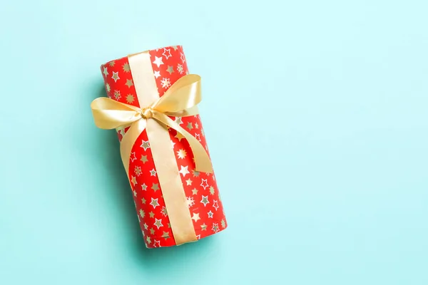 Envuelto Navidad u otro regalo hecho a mano de vacaciones en papel con cinta de oro sobre fondo azul. Caja de regalo, decoración de regalo en mesa de colores, vista superior con espacio para copiar —  Fotos de Stock