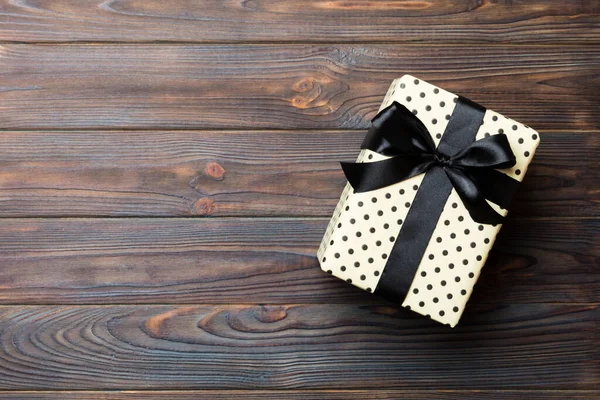 Hermosa caja de regalo con un lazo de color en la mesa de madera oscura. Vista superior con espacio de copia para su diseño. Concepto de Navidad —  Fotos de Stock