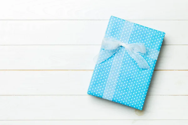 Papier geschenkdoos met gekleurd lint op witte houten ondergrond. bovenzijde — Stockfoto