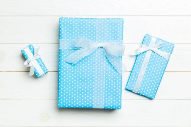 Beyaz ahşap masanın üzerinde renkli bir fiyonk olan güzel bir hediye kutusu. Tasarımınız için fotokopi alanı olan üst görünüm. Noel konsepti