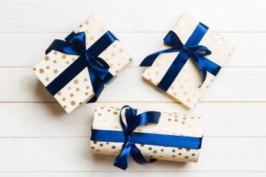 Beyaz ahşap masanın üzerinde renkli bir fiyonk olan güzel bir hediye kutusu. Tasarımınız için fotokopi alanı olan üst görünüm. Noel konsepti