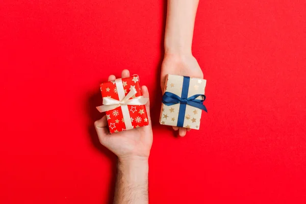 Vue du dessus d'une femme et d'un homme échangeant des cadeaux sur un backg coloré — Photo