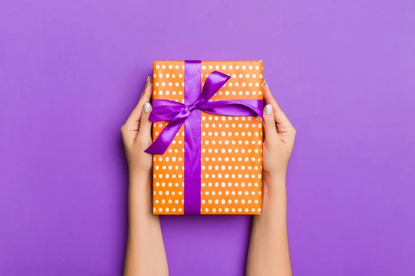 Pose plate de mains de femme tenant cadeau enveloppé et décoré avec — Photo