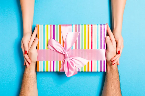 Widok mężczyzny i kobiety trzymających pudełko z prezentami na kolorowym woreczku — Zdjęcie stockowe