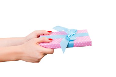 Kadın elleri, paketli Noel ya da mavi kurdeleli pembe kağıtta yapılan diğer Noel hediyelerini verir. Beyaz arkaplanda izole edilmiş, üst manzara. Şükran Günü hediye kutusu konsepti