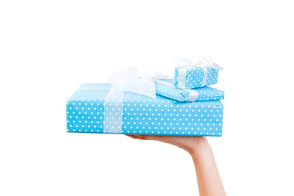Vrouw handen geven verpakt set van Kerstmis of andere vakantie met de hand gemaakt in blauw papier met wit lint. Geïsoleerd op witte achtergrond, bovenaanzicht. dankzegging Geschenkdoos concept — Stockfoto