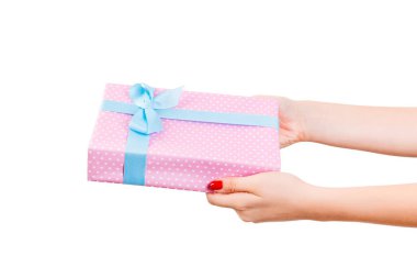 Kadın elleri, paketli Noel ya da mavi kurdeleli pembe kağıtta yapılan diğer Noel hediyelerini verir. Beyaz arkaplanda izole edilmiş, üst manzara. Şükran Günü hediye kutusu konsepti