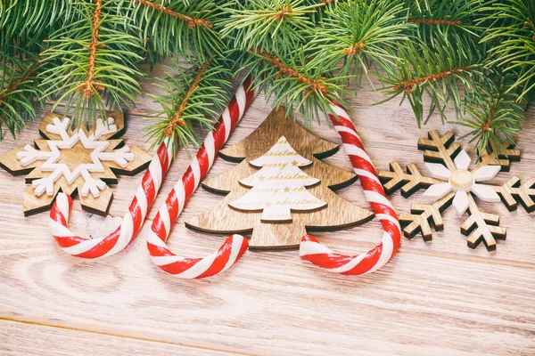 Bastones de caramelo de Navidad y copos de nieve sobre un fondo de madera. Tonificado — Foto de Stock