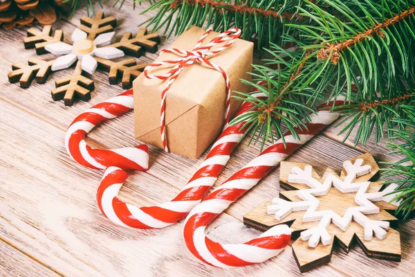 Confezione regalo di Natale, bastoncino di zucchero con fiocco di neve e ramo di abete sul tavolo di legno. Tonica — Foto Stock