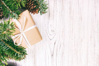 Noel kompozisyon geçmişi. Noel hediyesi olarak çam kozalakları ve tahta arka planda köknar dalları. Düz konum, üst görünüm, kopyalama alanı. Ayarlanmış