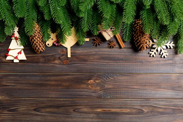 Вид сверху рамы из веток ели и праздничных украшений на деревянном фоне. Рождественская концепция с пустым пространством для дизайна — стоковое фото