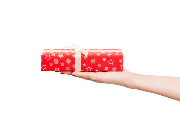 Las manos de mujer dan envuelto Navidad u otro regalo hecho a mano de vacaciones en papel rojo con cinta de oro. Aislado sobre fondo blanco, vista superior. Acción de Gracias Concepto de caja de regalo —  Fotos de Stock