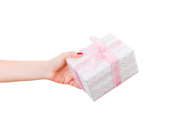 女人的手送给包装好的圣诞礼物或其他节日手工制作的带有粉色缎带的彩色纸礼物。 独立在白色背景上，顶部视图。 感恩礼盒的概念 — 图库照片