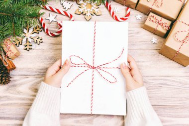 Kızın elinde çocukların Noel mektupları var. Hediye kutusu ve Noel süslemesi olan Noel mektupları. Ayarlanmış