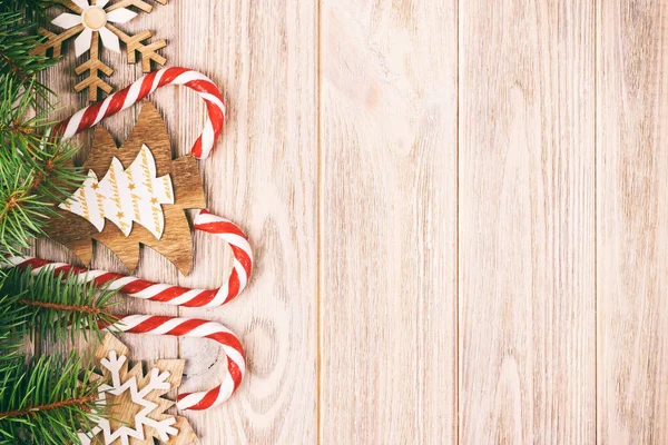Bengalas doces de Natal e flocos de neve em um fundo de madeira. Tonificado — Fotografia de Stock
