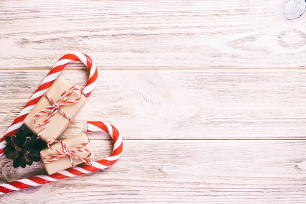 Bastoncini di zucchero e regalo di Natale su sfondo di legno marrone. Tonica — Foto Stock