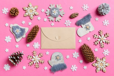 El sanatları zarfı, tatil oyuncakları ve pembe Noel arkaplanındaki süslemeler. Yeni yıl konsepti
