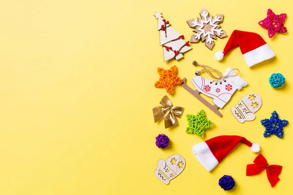 Widok z góry świąteczne dekoracje i Santa kapelusze na żółtym tle. Szczęśliwy wakacyjny pojęcie z kopia przestrzeń — Zdjęcie stockowe