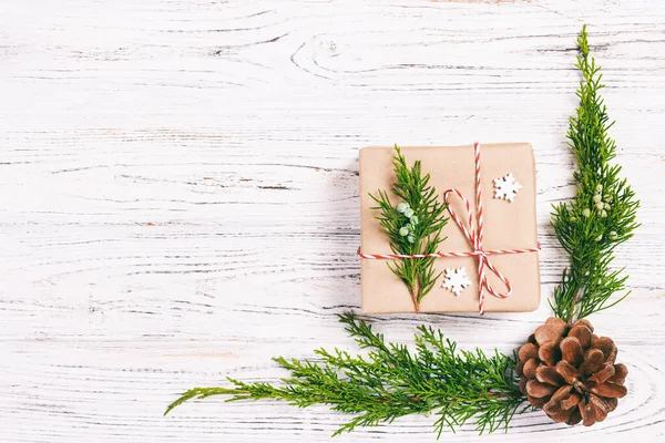 Kerstcompositie achtergrond. Kerstcadeau met dennenappels en dennentakken op houten ondergrond. Platte lay, bovenaanzicht, kopieerruimte. Getooid — Stockfoto