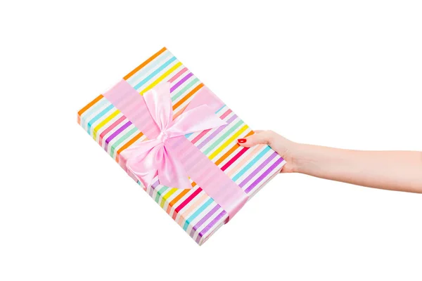 女人的手送给包装好的圣诞礼物或其他节日手工制作的带有粉色缎带的彩色纸礼物。 独立在白色背景上，顶部视图。 感恩礼盒的概念 — 图库照片