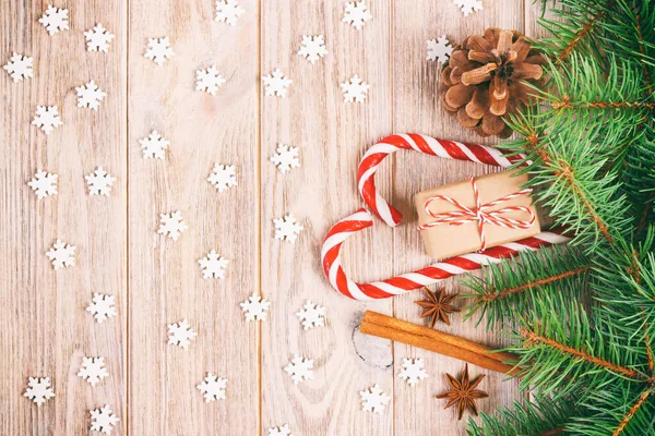 Χριστουγεννιάτικο κουτί δώρου, ζαχαροκάλαμο καραμέλα με νιφάδες χιονιού και κλαδί ελάτης σε ξύλινο τραπέζι. Γραμμένο — Φωτογραφία Αρχείου