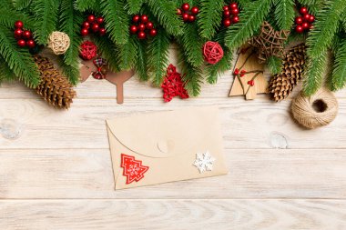 Zarfın en üst görüntüsü, Noel oyuncakları, dekorasyonlar ve ahşap arka planda köknar dalları. Yeni yıl tatili konsepti