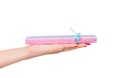 Kadın elleri, paketli Noel ya da mavi kurdeleli pembe kağıtta yapılan diğer Noel hediyelerini verir. Beyaz arkaplanda izole edilmiş, üst manzara. Şükran Günü hediye kutusu konsepti