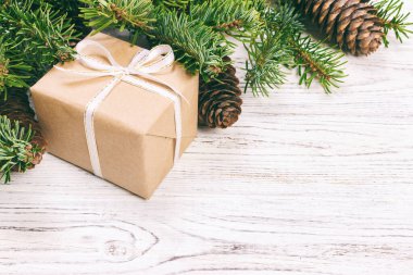 Noel kompozisyon geçmişi. Noel hediyesi olarak çam kozalakları ve tahta arka planda köknar dalları. Düz konum, üst görünüm, kopyalama alanı. Ayarlanmış