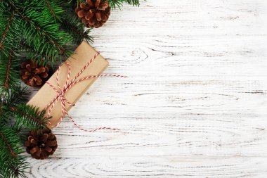 Noel kompozisyon geçmişi. Noel hediyesi olarak çam kozalakları ve tahta arka planda köknar dalları. Düz konum, üst görünüm, kopyalama alanı. Ayarlanmış