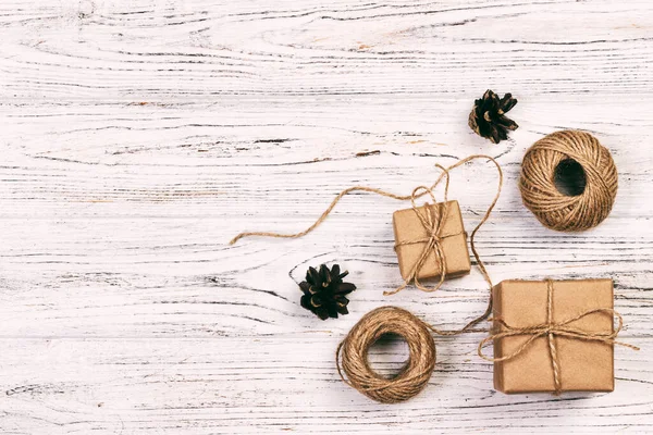 Christmas background or Holiday greeting card. christmas present box with fir tree branch and decorations on wooden table. Top view with copy space. Toned