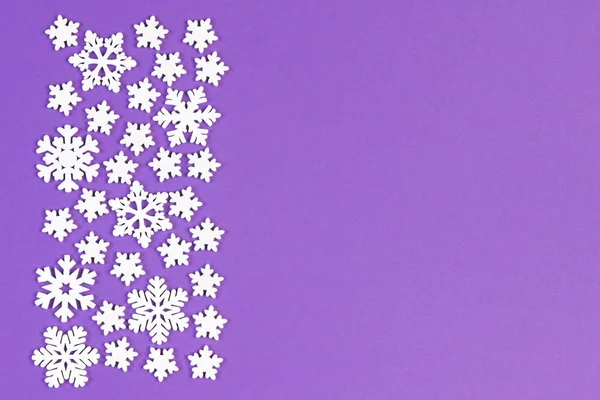 Draufsicht auf weiße Schneeflocken auf buntem Hintergrund. Winterwetter-Konzept mit Kopierraum. Frohe Weihnachten — Stockfoto