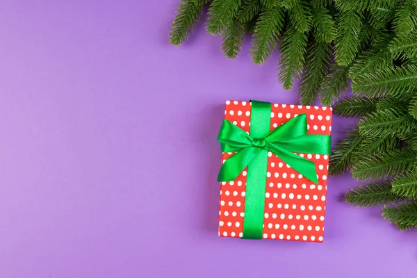 Vista superior de la caja de regalo y ramas de abeto sobre un fondo colorido. Feliz concepto de Navidad con espacio vacío para su diseño —  Fotos de Stock