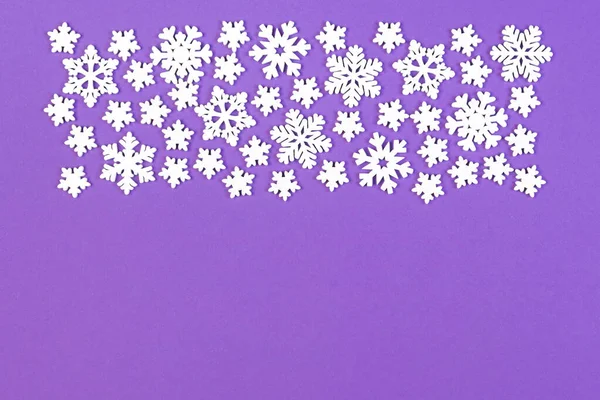 Top view of winter ornament made of white snowflakes on colorful background. Happy New Year concept with copy space