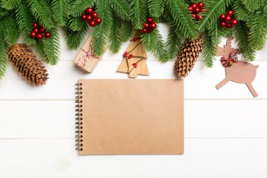 En tepedeki köknar ağacı manzarası, yeni yıl süslemeleri ve tahta arka plandaki defter. Kopya alanı ile Noel kavramı