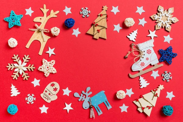 Вид сверху праздничных игрушек и украшений на красном рождественском фоне. Новогодняя концепция с копировальным пространством — стоковое фото