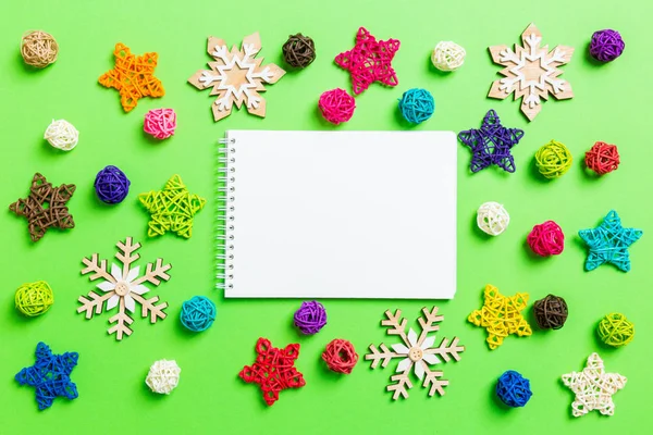 Bovenaanzicht van het notitieboek. Nieuwjaarsdecoraties op groene achtergrond. Feestelijke sterren en ballen. Vrolijk kerstconcept — Stockfoto