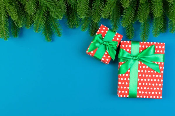 Vista superior de la caja de regalo y ramas de abeto sobre un fondo colorido. Feliz concepto de Navidad con espacio vacío para su diseño —  Fotos de Stock