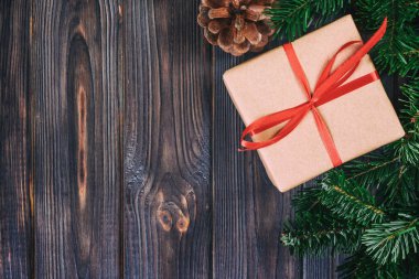 Noel kompozisyon geçmişi. Noel hediyesi olarak çam kozalakları ve tahta arka planda köknar dalları. Düz konum, üst görünüm, kopyalama alanı. Ayarlanmış