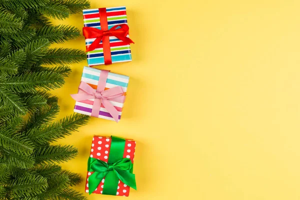 Bovenaanzicht van geschenkdoos en dennenboom takken op kleurrijke achtergrond. Merry Christmas concept met lege ruimte voor uw ontwerp — Stockfoto