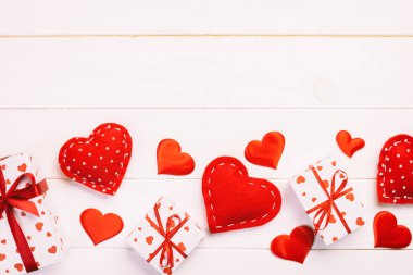 Sevgililer veya diğer tatil el yapımı mevcut kağıt ile tatil sarmalayıcı kırmızı kalpler ve hediye kutusunda. Tasarım için kopya alanı görünümüyle Beyaz ahşap masa üstü, boş alanı kutusu hediye sunmak